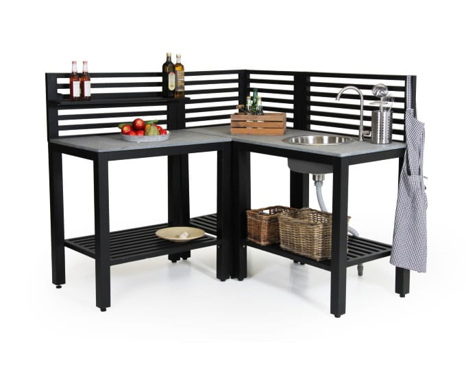 Nowoczesna jednostka kuchenna z czarnymi szafkami, zintegrowanym zlewem, blatem i półkami do przechowywania, wyposażona w warzywa, oleje i ręcznik w kratkę.