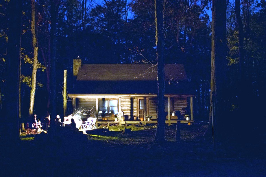 chata w lesie oświetlona ogniskiem