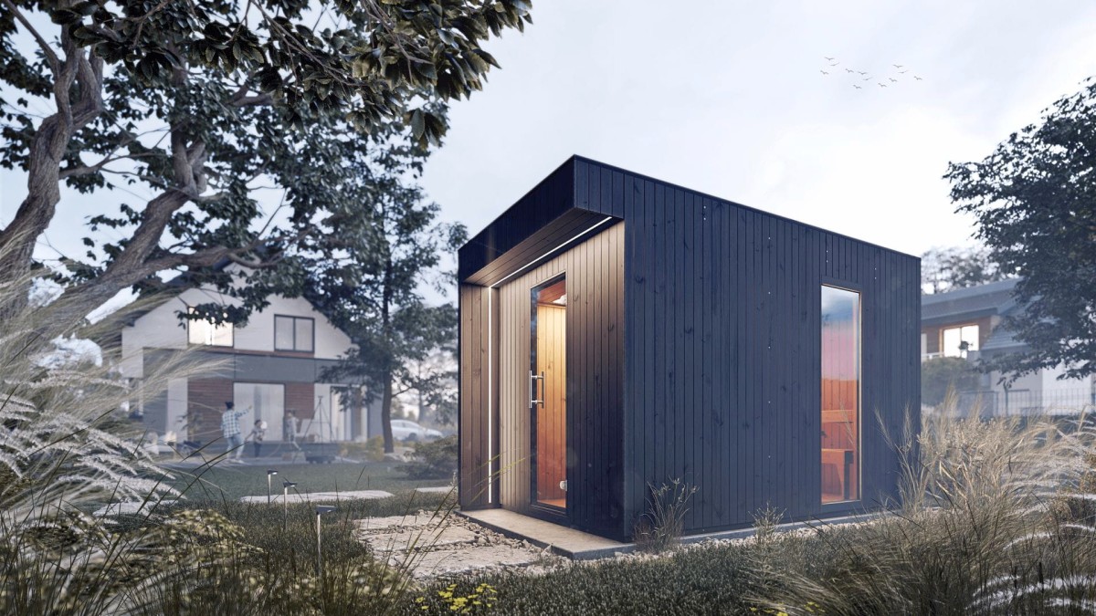 Nowoczesna sauna Musta z ciemną drewnianą fasadą i dużymi szklanymi drzwiami, położony w spokojnym ogrodzie w pobliżu domów, otoczony drzewami i wysokimi trawami.