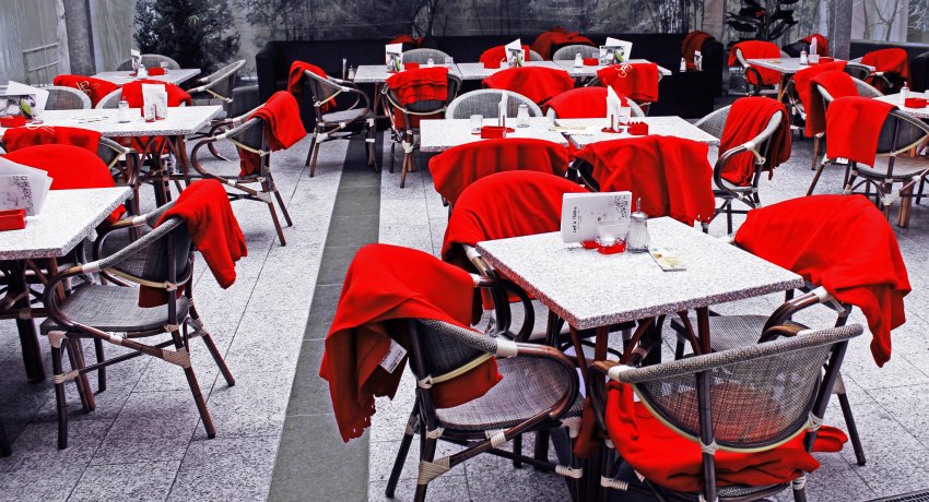 stoliki z krzeslami przykrytymi kocami przy restauracji